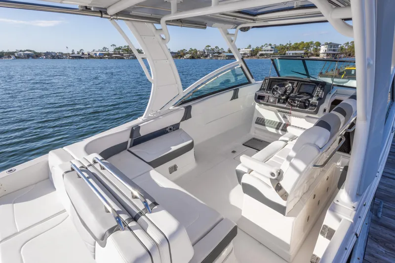Slide: The Image of 2020 Chaparral 300 OSX boat interior with helm and seating, docked by the water. - 33