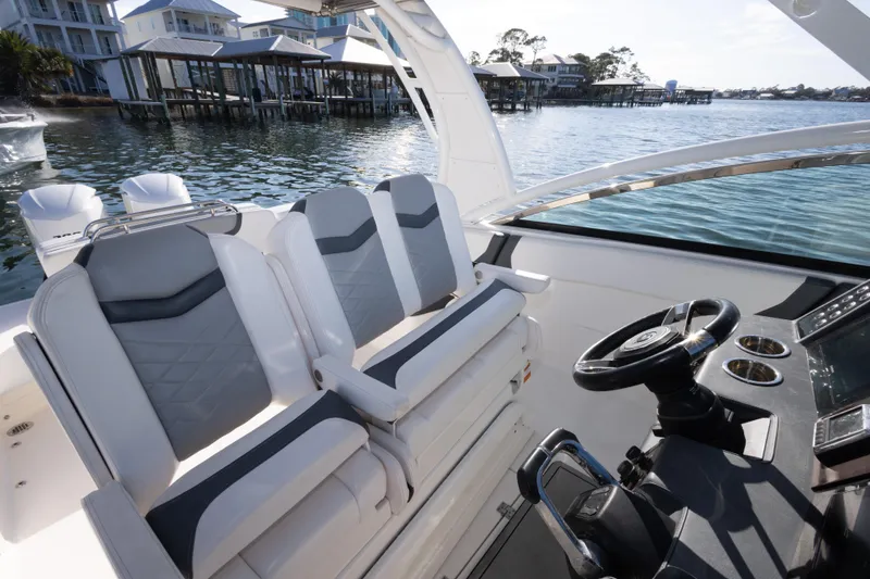 Slide: The Image of 2020 Chaparral 300 OSX boat interior with dual seats and steering wheel, dockside view. - 39