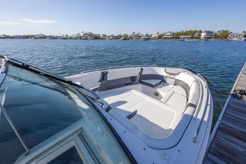 Slide: The Image of 2020 Chaparral 300 OSX boat docked on calm water, featuring spacious seating area. - 45