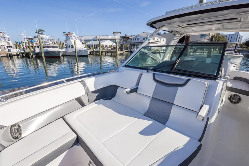 Slide: The Image of 2020 Chaparral 300 OSX boat with spacious seating at a marina. - 48