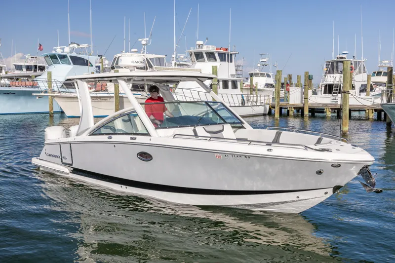 Slide: The Image of 2020 Chaparral 300 OSX boat docked in marina, surrounded by other vessels. - 7