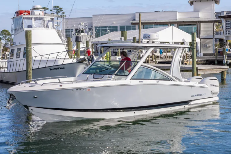 Slide: The Image of 2020 Chaparral 300 OSX boat docked at marina, featuring sleek design and Yamaha engines. - 8