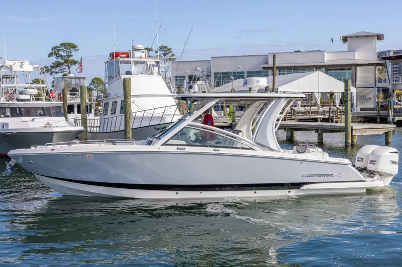 Slide: The Image of 2020 Chaparral 300 OSX boat docked at marina with clear blue sky. - 9