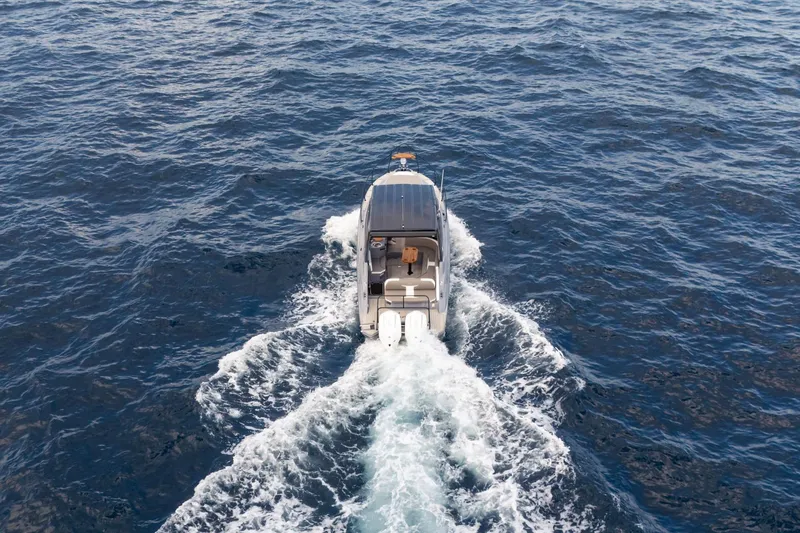 Slide: The Image of Aerial view of 2026 Hanover 305 boat cruising on open water. - 12