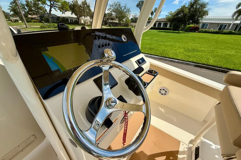 Slide: The Image of 2025 Scout 240 XSF boat dashboard with steering wheel and navigation display. - 16