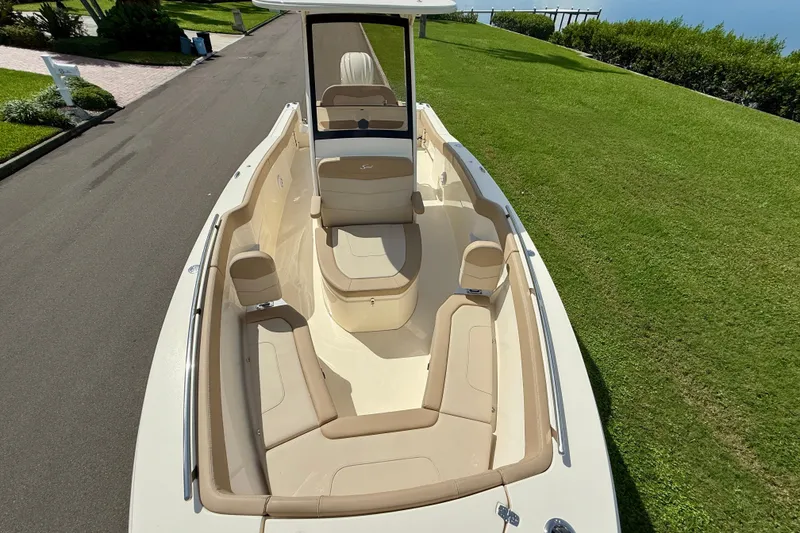 Slide: The Image of 2025 Scout 240 XSF boat with spacious seating, parked on a lush green lawn. - 26