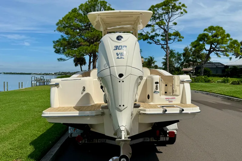 Slide: The Image of 2025 Scout 240 XSF boat with powerful 300 V6 engine, parked near scenic waterfront. - 4