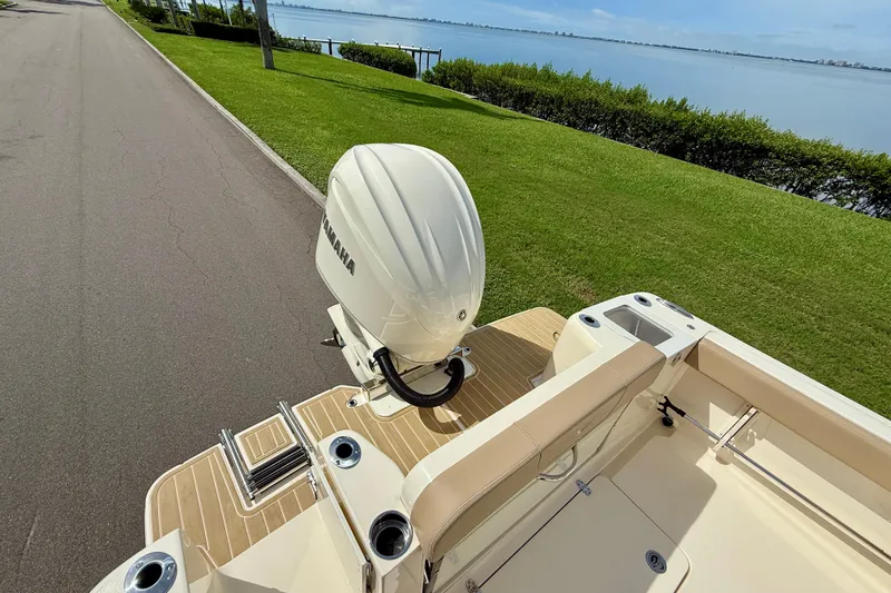 Slide: The Image of 2025 Scout 240 XSF boat with Yamaha engine, docked by a scenic waterfront. - 7