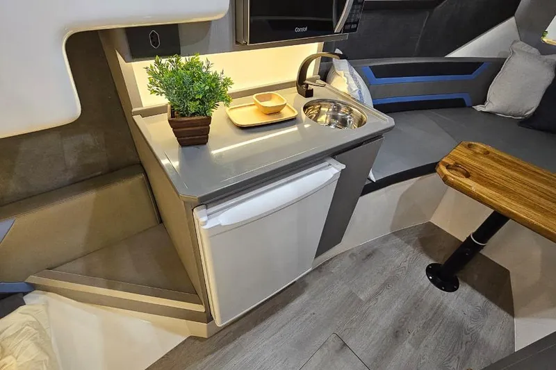 Slide: The Image of Modern Hanover 327 RV interior with kitchenette, sink, fridge, and seating area, 2026 model. - 19