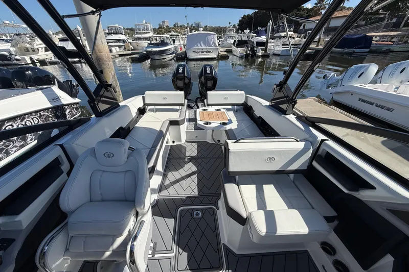 Slide: The Image of 2024 Cobalt R8 Outboard boat interior with luxurious seating at a marina. - 17