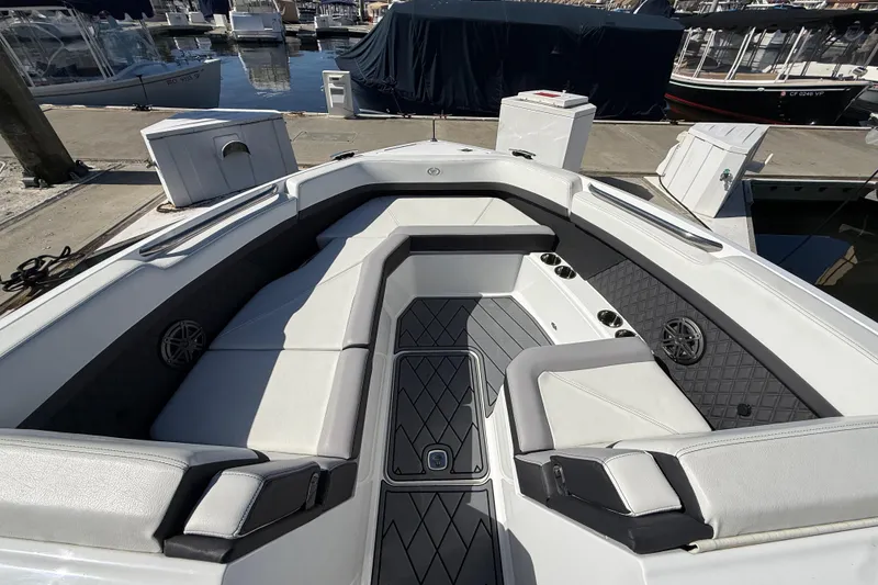 Slide: The Image of 2024 Cobalt R8 Outboard boat interior with luxurious seating at a marina. - 18