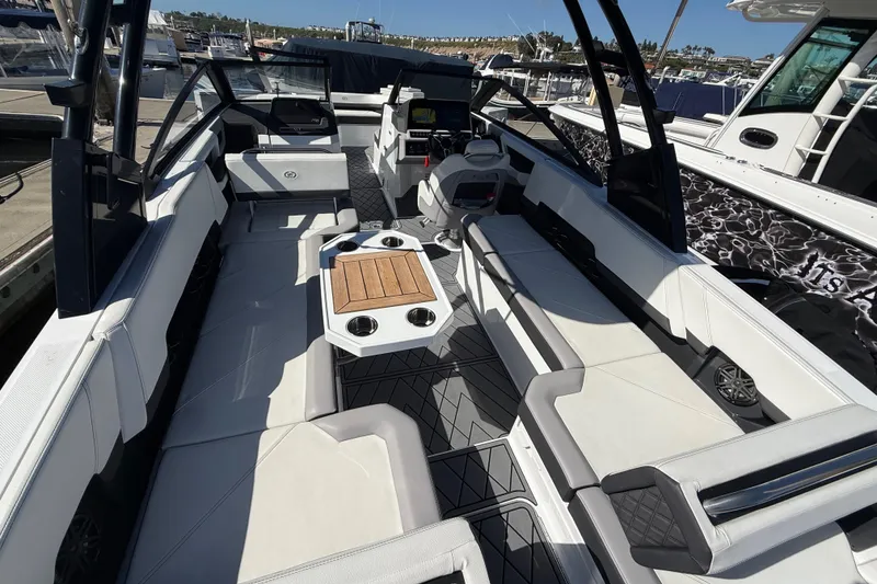 Slide: The Image of 2024 Cobalt R8 Outboard boat interior with spacious seating and modern design at a marina. - 5