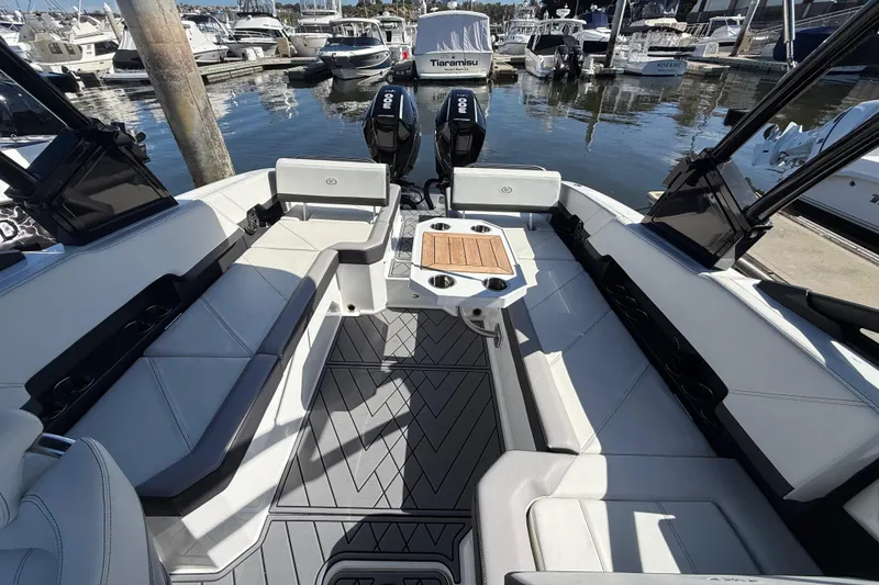 Slide: The Image of 2024 Cobalt R8 Outboard boat interior with seating and table, docked at marina. - 8