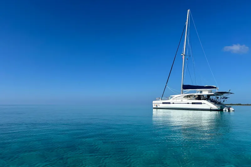 Slide: The Image of Sailing catamaran Leopard 48, 2013 model, anchored on clear blue ocean under bright sky. - 2