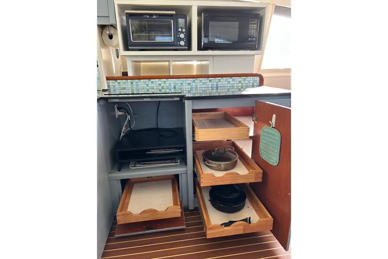 Slide: The Image of Kitchen area in a 2013 Leopard 48 yacht with appliances and storage drawers. - 22