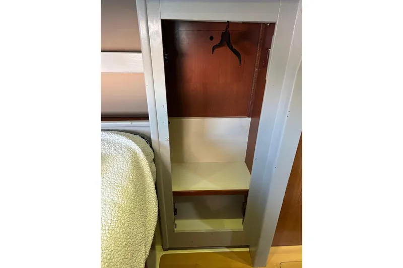 Slide: The Image of Empty closet in 2013 Leopard 48 yacht interior with wooden finish and hanger. - 27