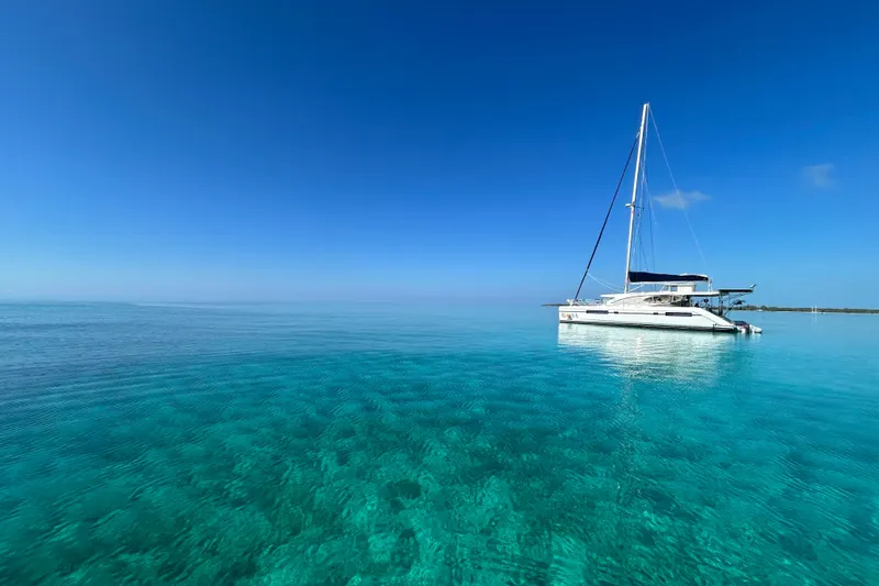 Slide: The Image of Sailing catamaran Leopard 48 on clear turquoise water, under a bright blue sky. - 3