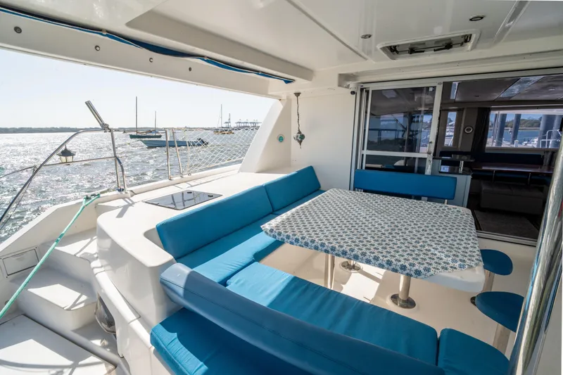Slide: The Image of Outdoor seating area on a 2013 Leopard 48 yacht with blue cushions and ocean view. - 33