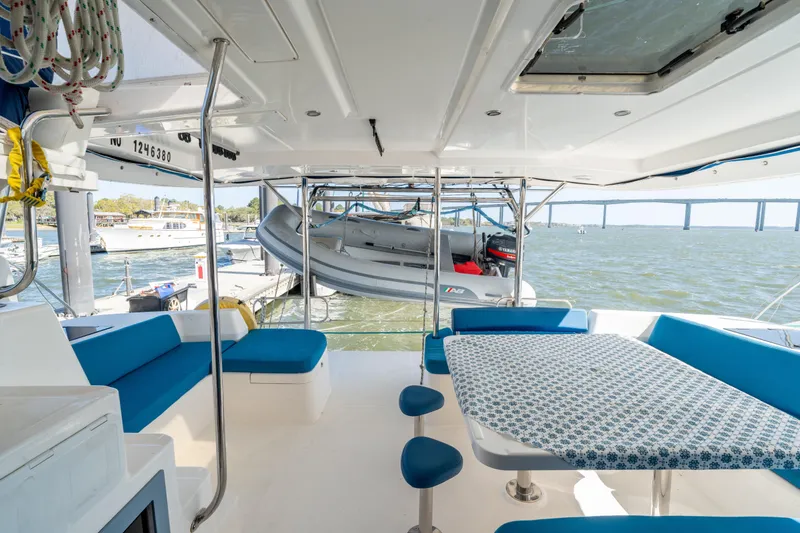 Slide: The Image of Leopard 48 yacht interior with blue seating, table, and ocean view, 2013 model. - 34