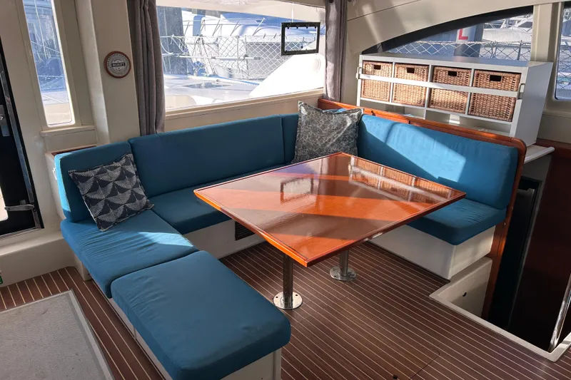 Slide: The Image of Luxurious 2013 Leopard 48 yacht interior with blue seating and wooden table. - 47