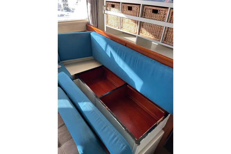 Slide: The Image of Interior of 2013 Leopard 48 yacht with blue cushioned seating and storage compartments. - 52