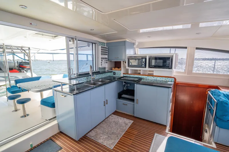 Slide: The Image of Interior of a 2013 Leopard 48 yacht featuring a modern kitchen and dining area. - 54