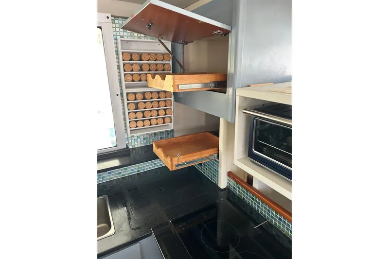 Slide: The Image of Modern kitchen with pull-out shelves, spice rack, and oven in a 2013 Leopard 48 yacht. - 55