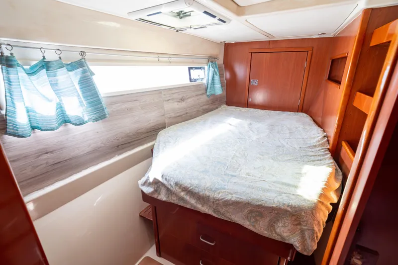 Slide: The Image of Cozy bedroom interior of 2013 Leopard 48 yacht with wooden accents and natural light. - 63