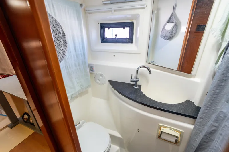 Slide: The Image of Bathroom interior of a 2013 Leopard 48 yacht, featuring sink, toilet, and window. - 66