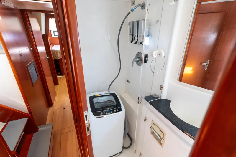 Slide: The Image of Laundry area inside a 2013 Leopard 48 yacht, featuring a compact washing machine. - 68