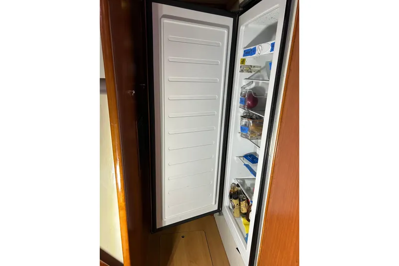 Slide: The Image of Open refrigerator inside 2013 Leopard 48 yacht, showcasing organized food and beverages. - 72