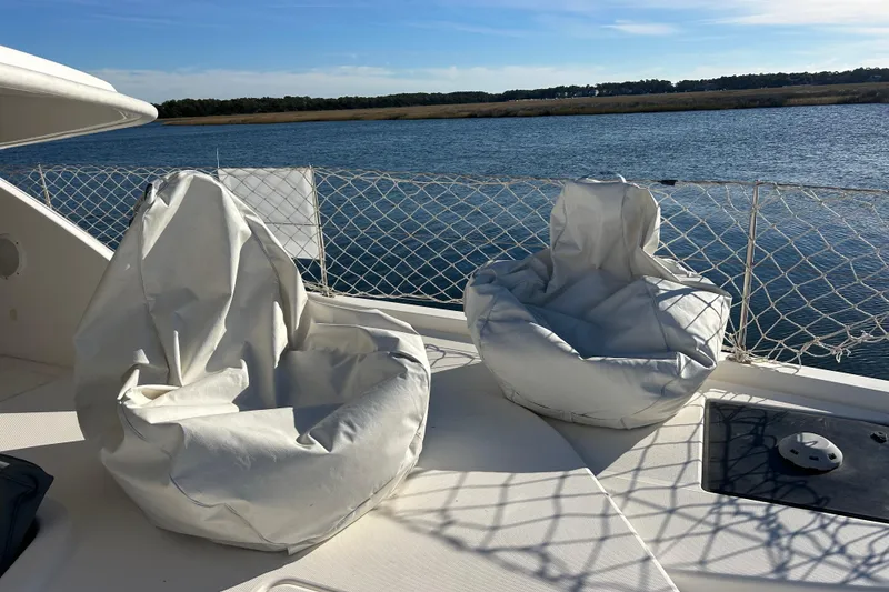 Slide: The Image of Two white bean bag chairs on a 2013 Leopard 48 yacht deck by the water. - 9