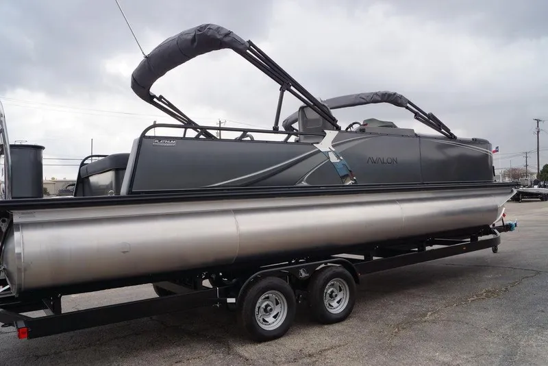 The Image of 2026 Avalon Catalina Versatile Rear Bench pontoon boat on trailer, overcast sky. - 1