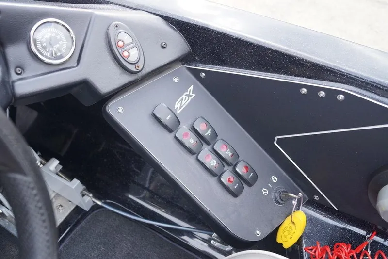 Slide: The Image of Control panel of a 2019 Skeeter ZX250 boat with switches and key ignition. - 12