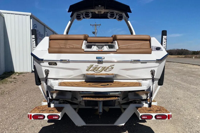 Slide: The Image of 2025 Tigé Ultré 25ZX boat rear view with tan seating and sleek design. - 3