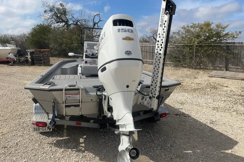Slide: The Image of 2025 Vexus ACX2000 boat with Suzuki 150 outboard motor, parked on gravel. - 3