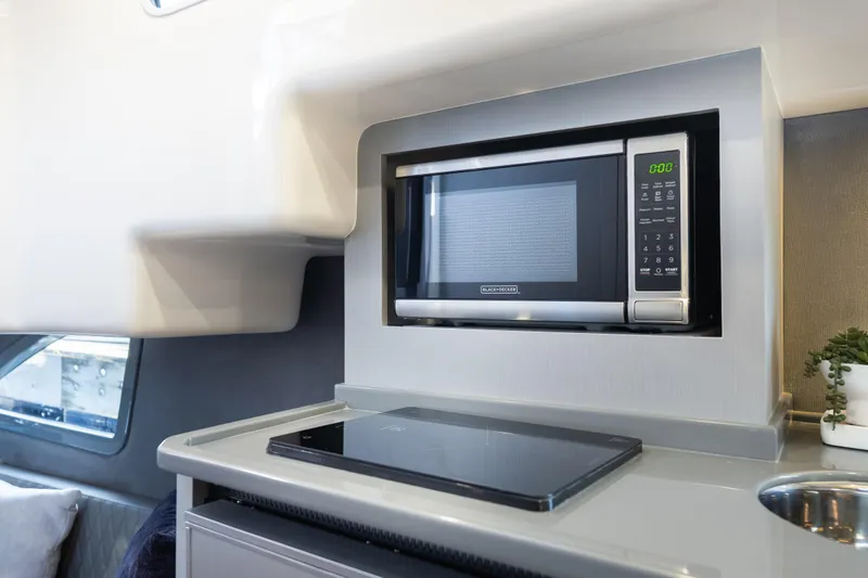Slide: The Image of Modern kitchen area in Hanover 347 yacht, featuring a built-in microwave and sleek cooktop, 2026 model. - 45