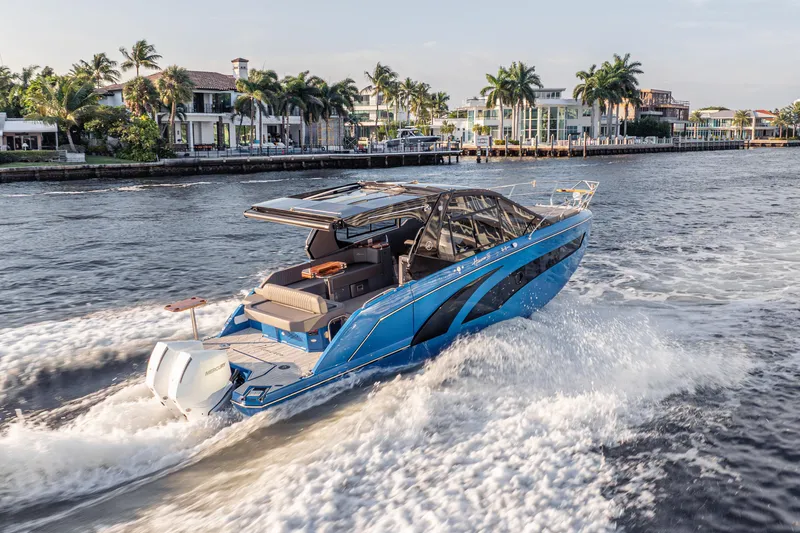 Slide: The Image of Luxury Hanover 347 boat cruising near waterfront homes, 2026 model. - 9