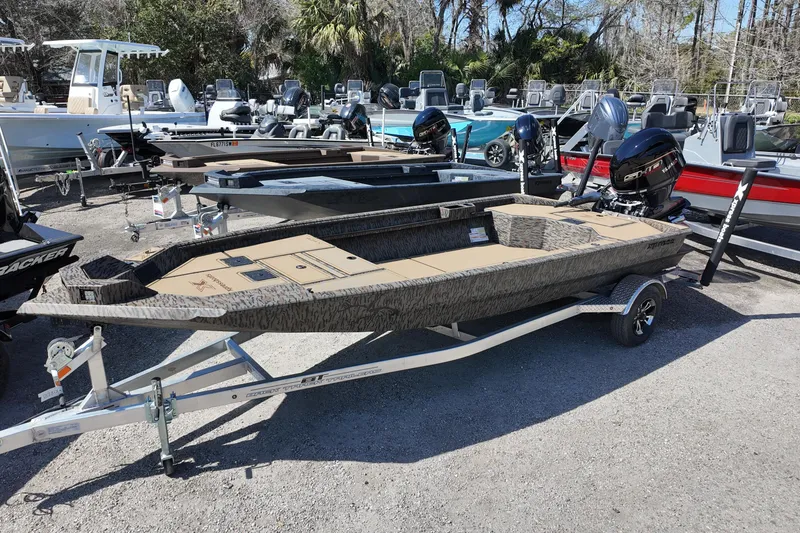 The Image of 2026 Xpress X18DB boat on trailer, surrounded by other boats in outdoor setting. - 0
