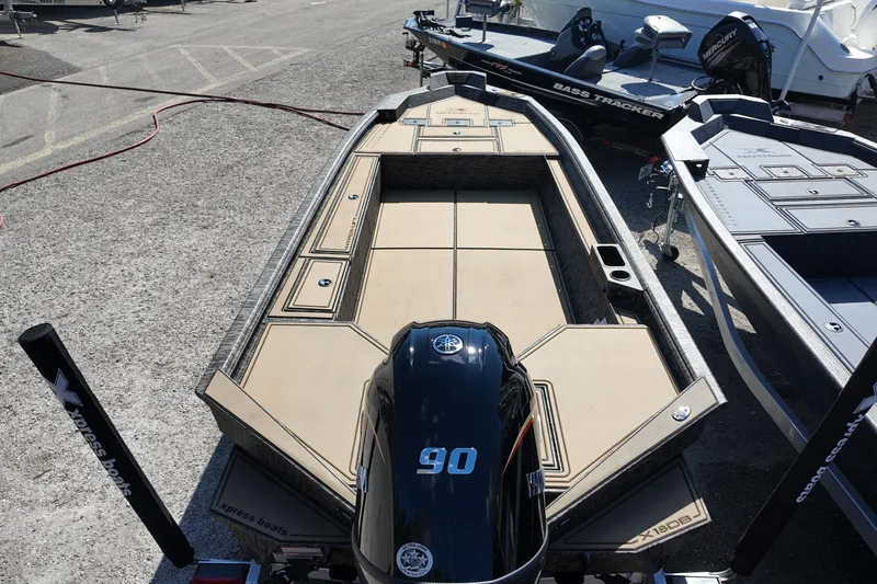 Slide: The Image of 2026 Xpress X18DB boat with Yamaha 90 engine, parked alongside other boats. - 3
