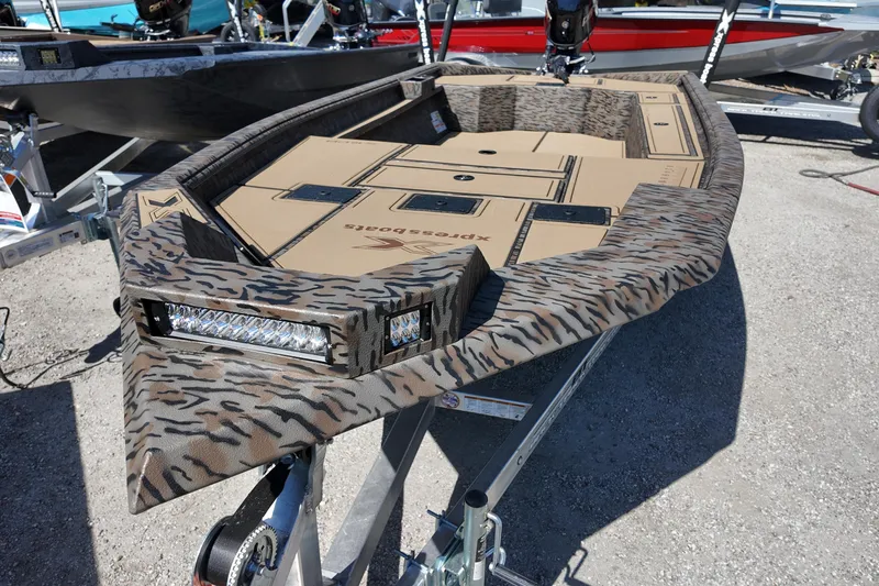 Slide: The Image of 2026 Xpress X18DB boat with camouflage design on a trailer. - 7