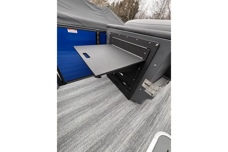 Slide: The Image of 2026 Bennington 22 M FASTBACK boat interior with fold-out table and gray flooring. - 16