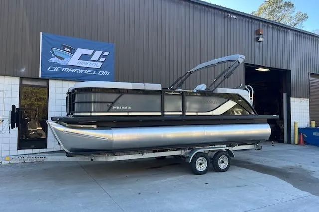 The Image of 2026 Godfrey Sweetwater 2086 SB pontoon boat on trailer outside marine shop. - 1