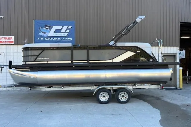 Slide: The Image of 2026 Godfrey Sweetwater 2086 SB pontoon boat on trailer outside marine shop. - 2