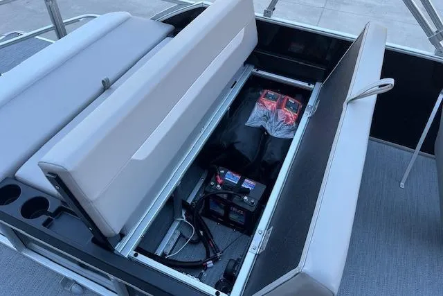 Slide: The Image of Open storage compartment in 2026 Godfrey EX 2286 SFLX boat, revealing battery and accessories. - 12