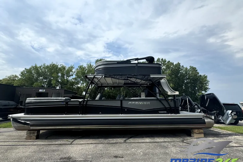 The Image of 2026 Premier Escalante pontoon boat with sleek design, parked outdoors under cloudy sky. - 0