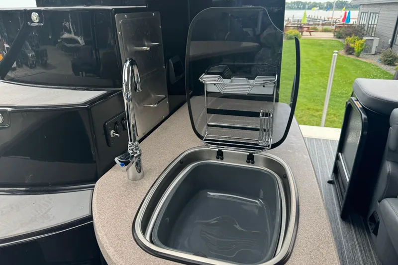 Slide: The Image of 2026 Premier Escalante boat kitchen sink with faucet and storage, outdoor setting. - 15