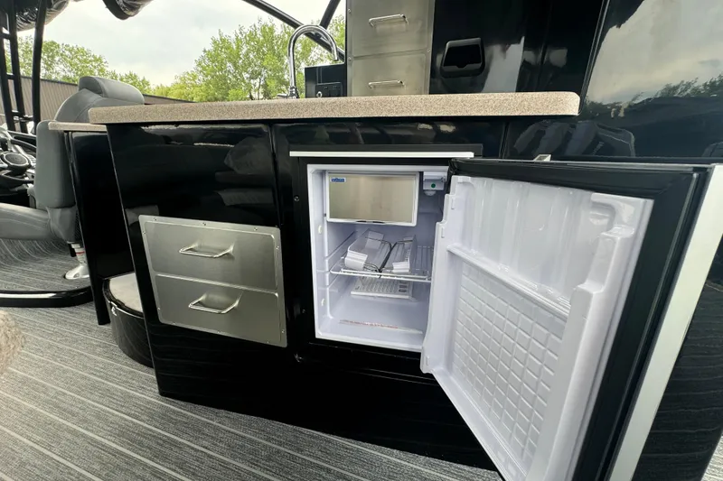 Slide: The Image of 2026 Premier Escalante interior with open mini fridge and storage drawers. - 17