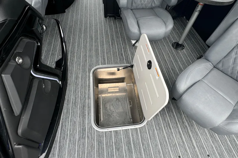 Slide: The Image of 2026 Premier Escalante interior with open floor storage compartment and gray seating. - 32