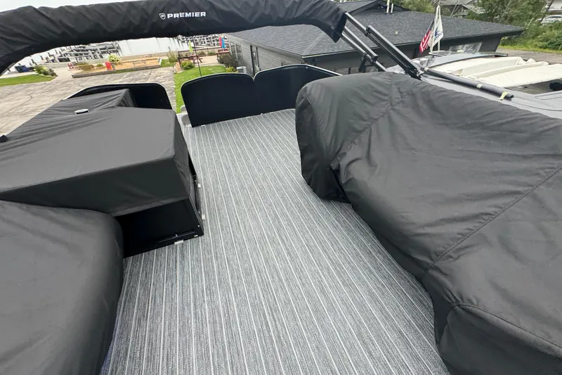 Slide: The Image of 2026 Premier Escalante boat deck with black covers and striped flooring. - 47